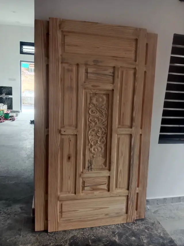 Wooden door with carved centre panel fitted in a wooden frame