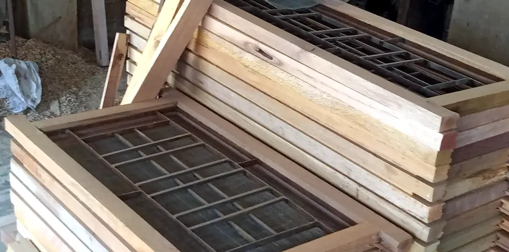 Stack of wooden window frames with grills at our workshop